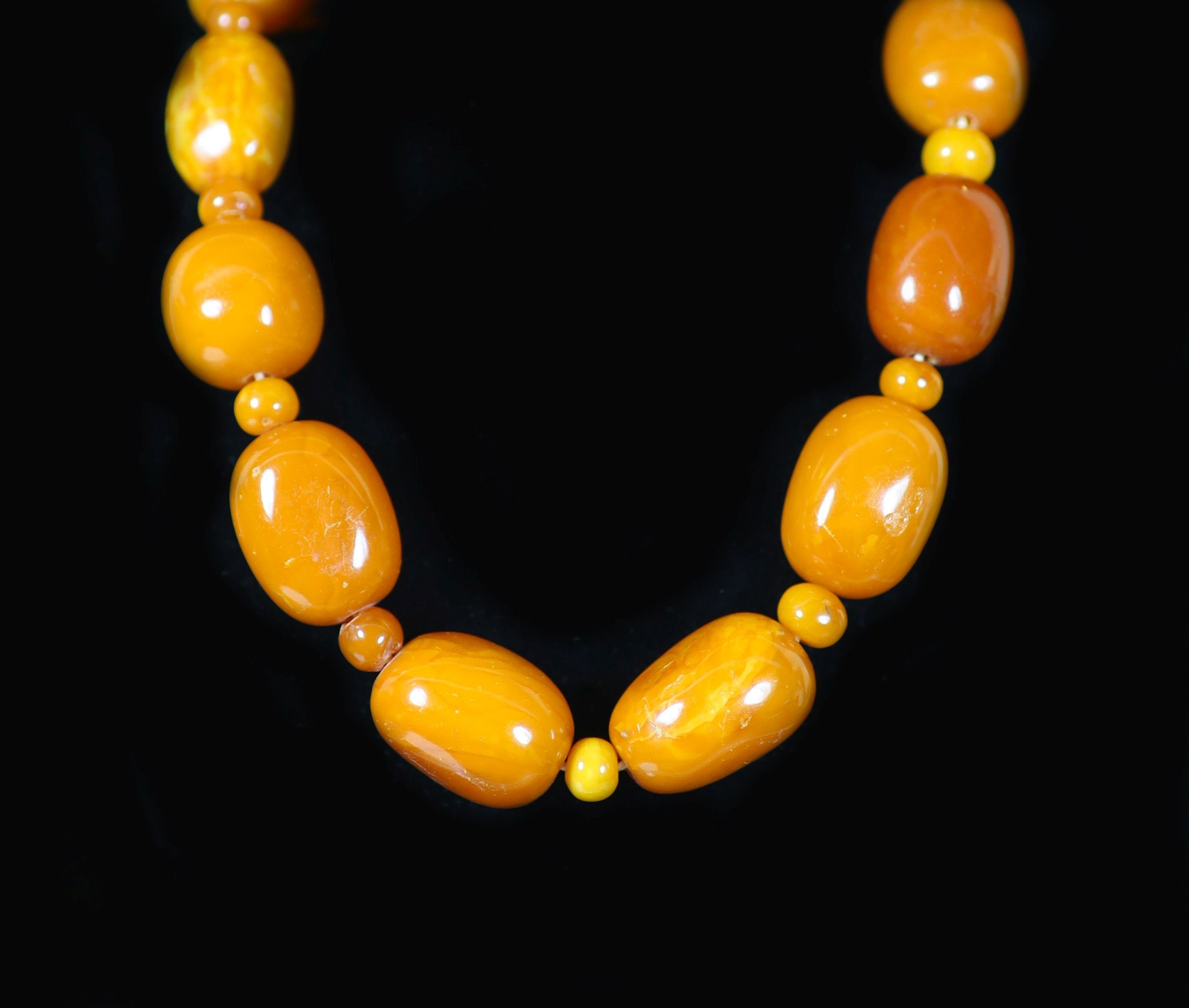 A single stand barrel shaped amber bead necklace, with amber bead spacers